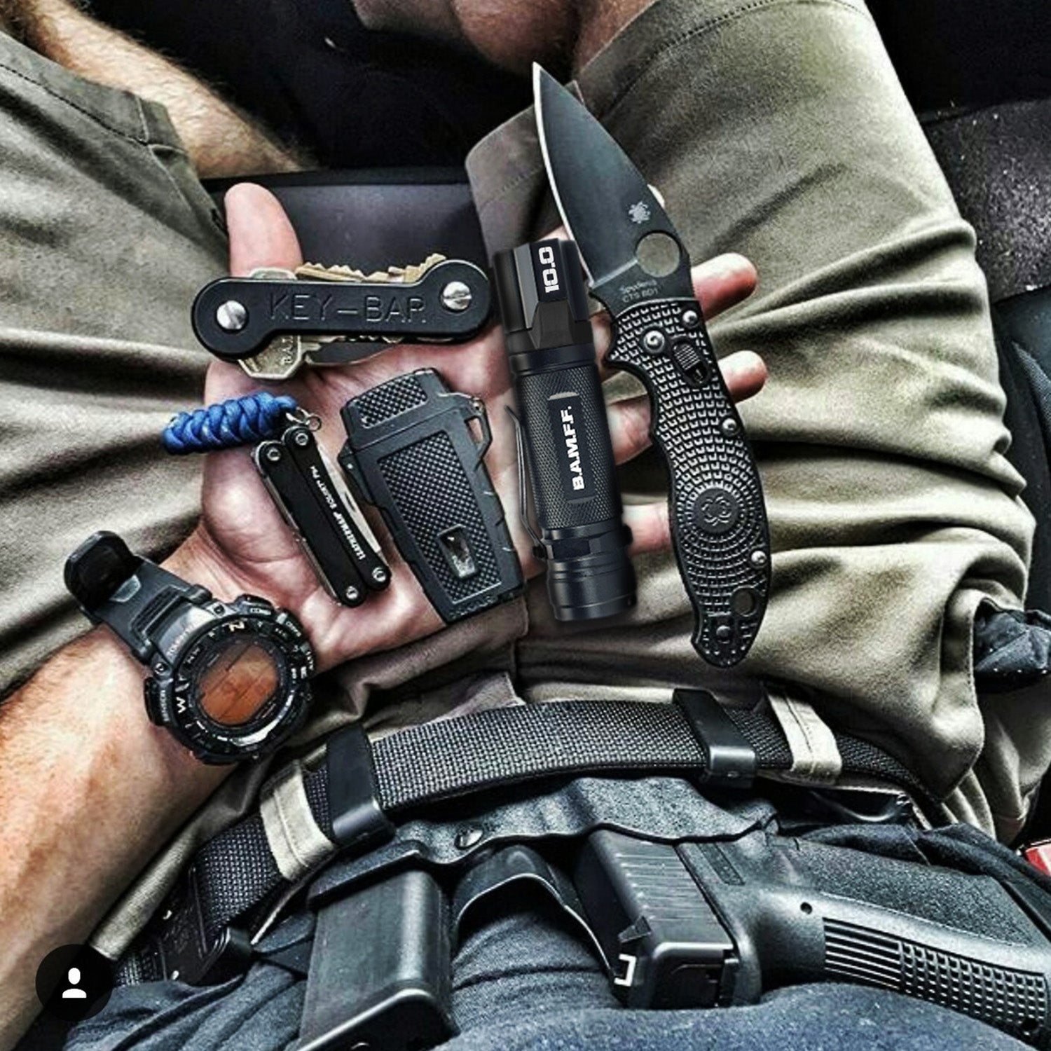 POV image looking into a male's lap full of tactical gear including a gun, knife, multi-tool, BAMFF 10 tactical flashlight, and more
