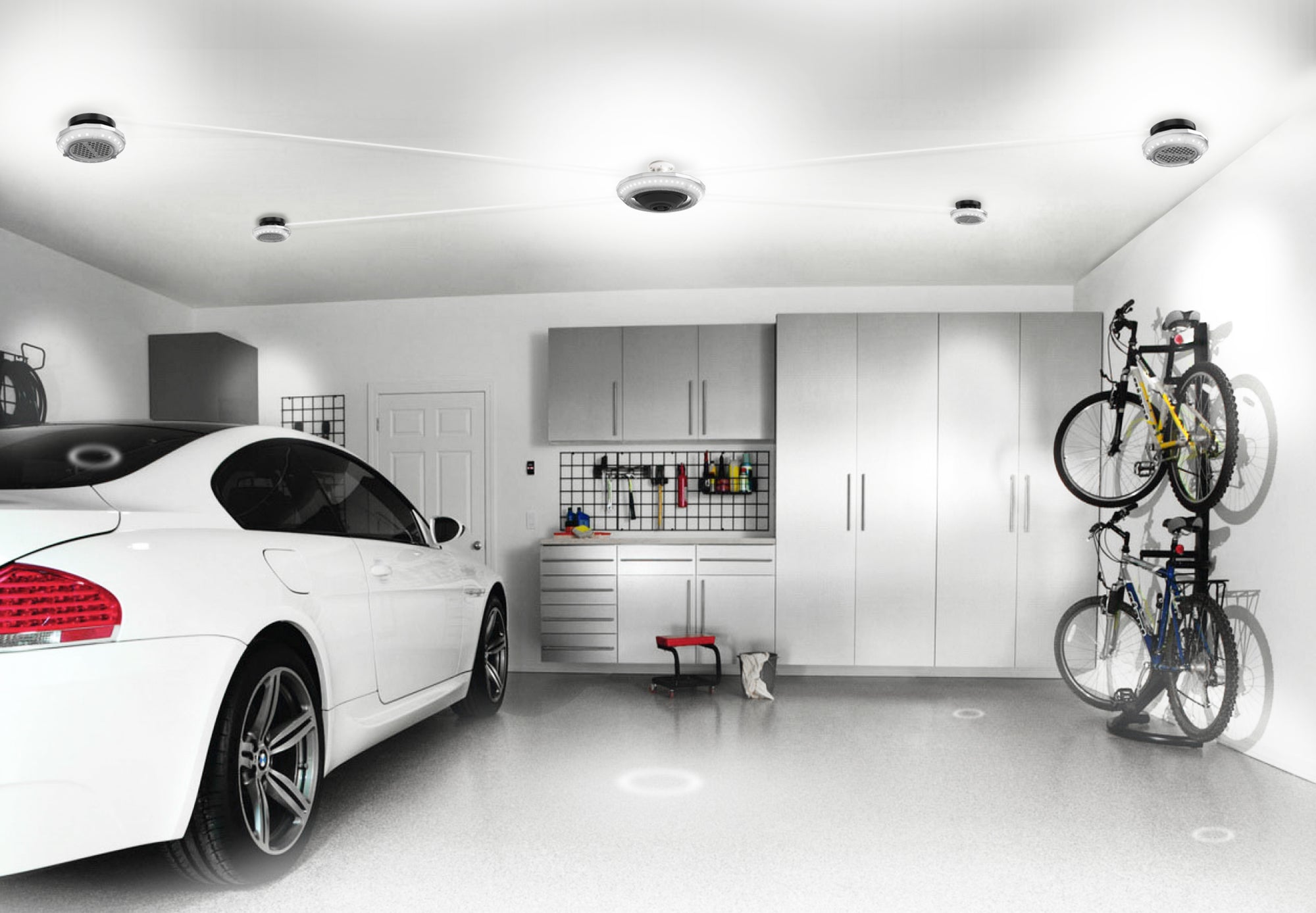 Very well lit 2 car garage with a white sports car parked on the left side. Full room lighting provided by an MPI system from STKR Concepts.