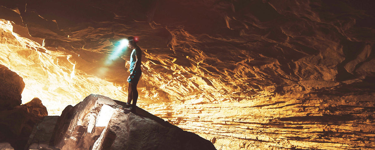 FLEXIT Headlamp poster featuring someone spelunking in a cave wearing a headlamp
