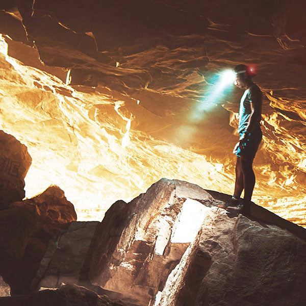 FLEXIT Headlamp poster featuring someone spelunking in a cave wearing a headlamp