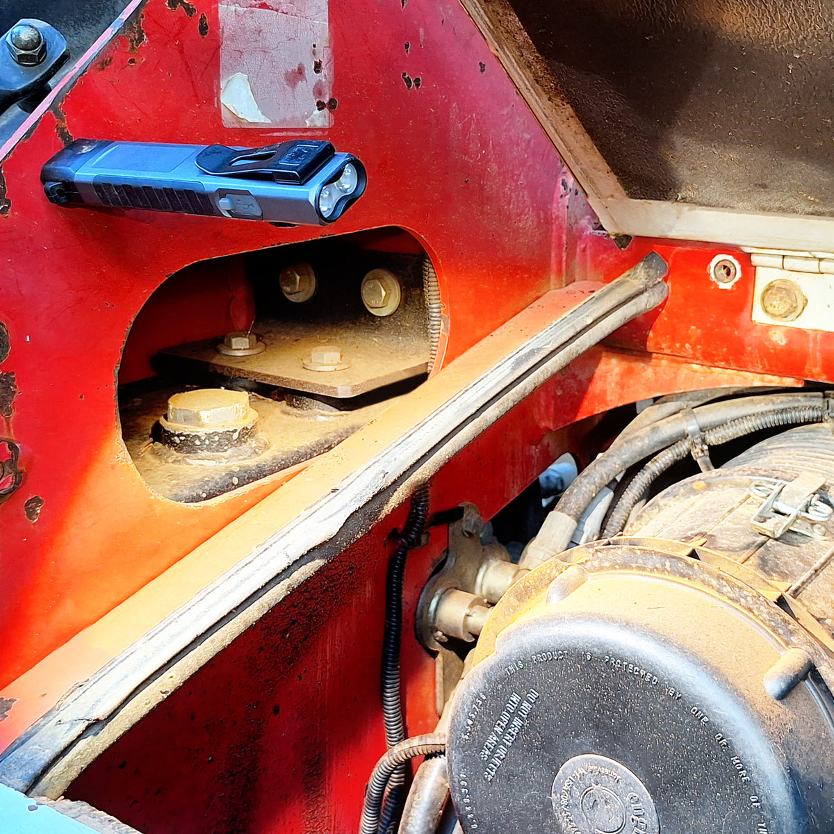 LP-EDC+ 8.0 Low Profile Everyday Carry Ultra-Thin Flashlight lighting up a skid steer's Kubota engine