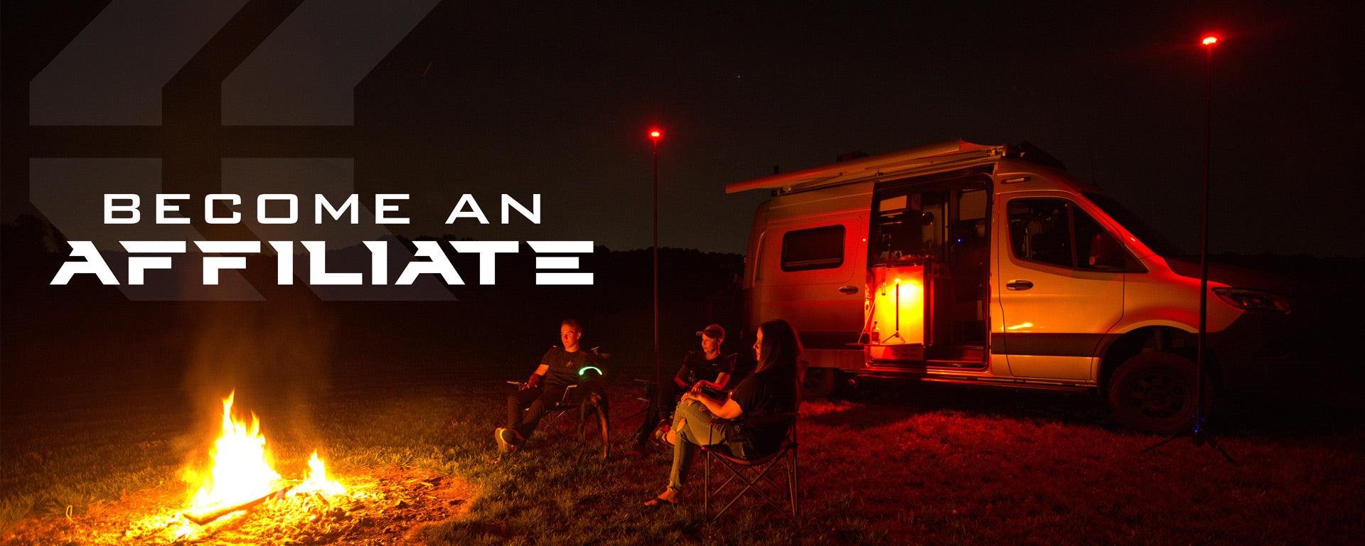 STKR's 'become an affiliate' banner. Image of 3 people sitting in-between a camper van and a campfire at night. Two STKR FLi OVER-LANDER telescoping lights are also lighting up the area.