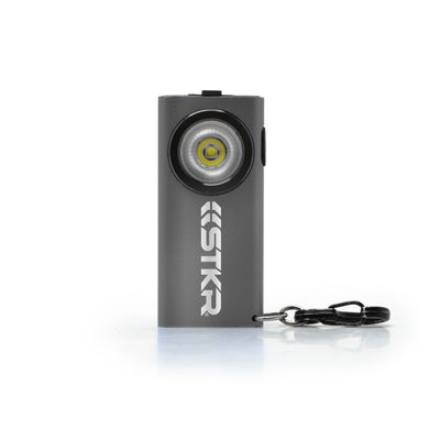 Compact rectangular flashlight with keychain attachment and STKR branding on the front.