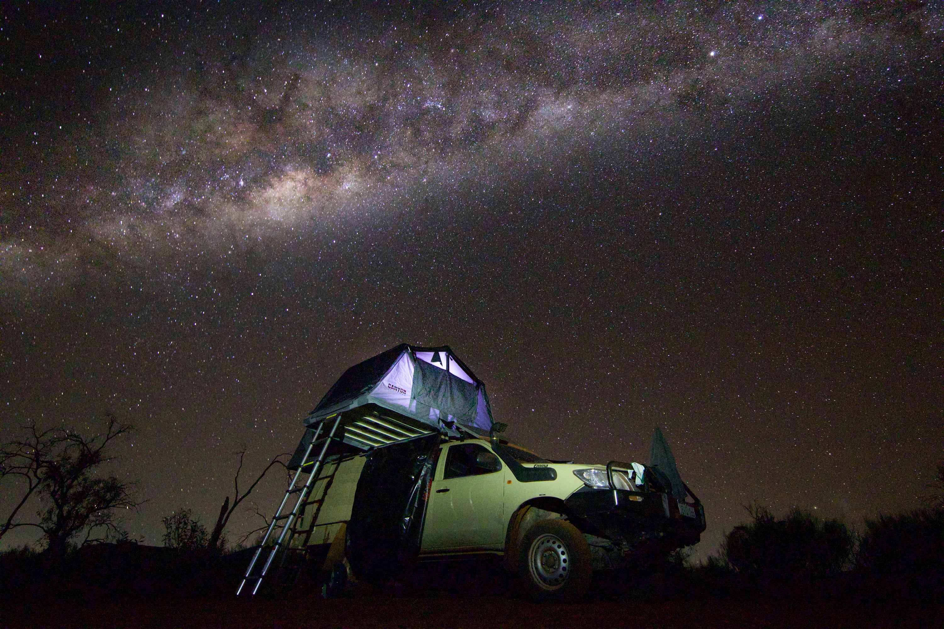 overlanding image of a vehicle top tent camper with the galaxy in the background