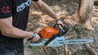 Palm Protectors worn on both hands running a chainsaw in the woods