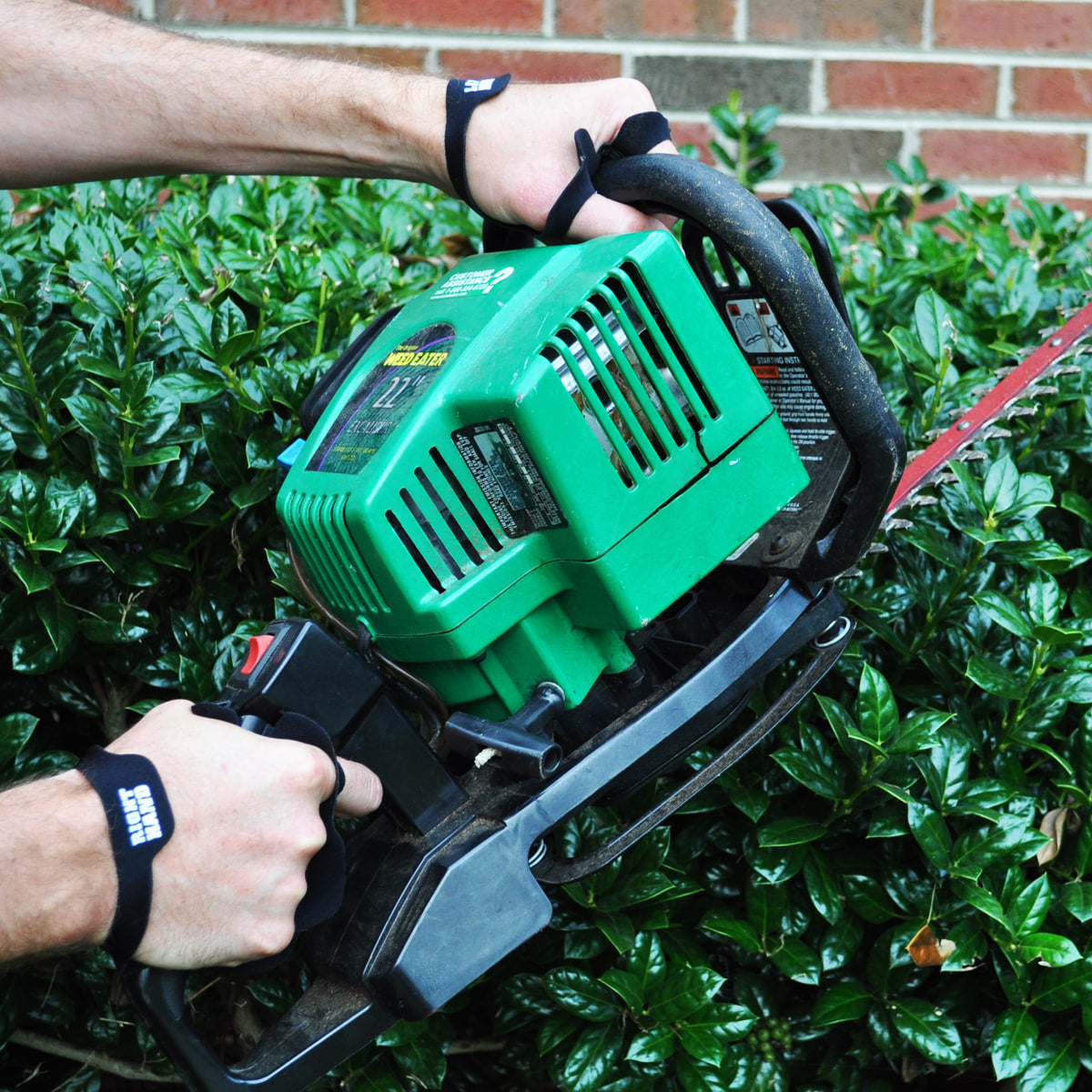 Palm Protectors worn on both hands running a gas hedge trimmer